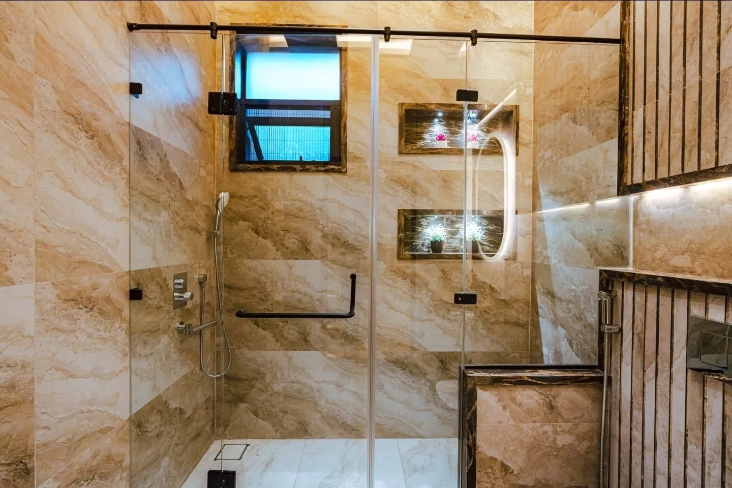 Glass shower enclosure with wall-mounted fittings.