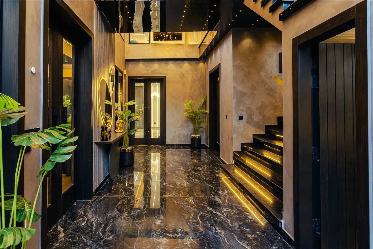 Entrance hall with polished dark flooring and a staircase.