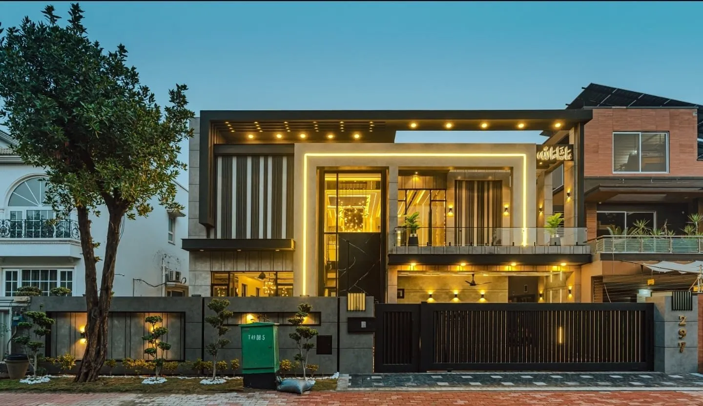 Front exterior of the house with its lights on at dusk.